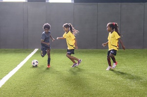 Two girls playing football on a field