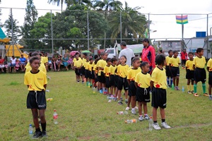 Kids in their uniform queuing and listening to the coach