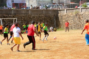 Children and adults playing football together